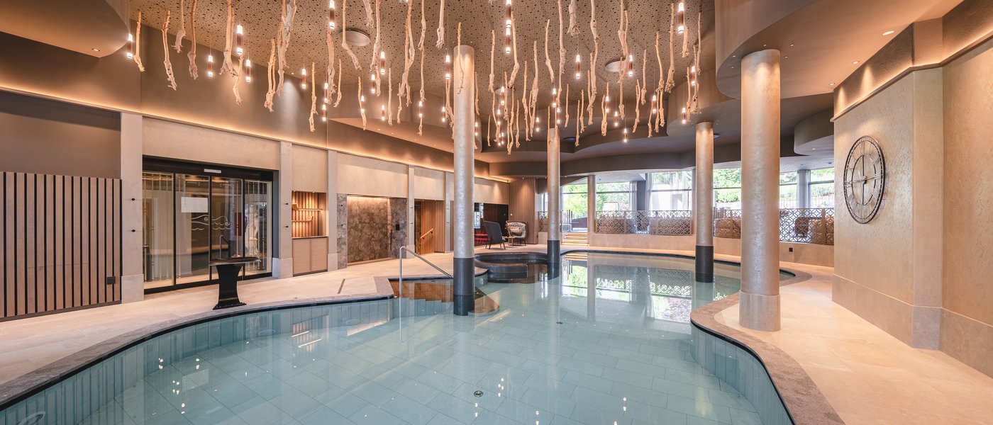 Urlaub in Südtirol im Hotel mit Pool am See Moderner Innenpool mit ungewöhnlicher Deckenbeleuchtung und Säulen