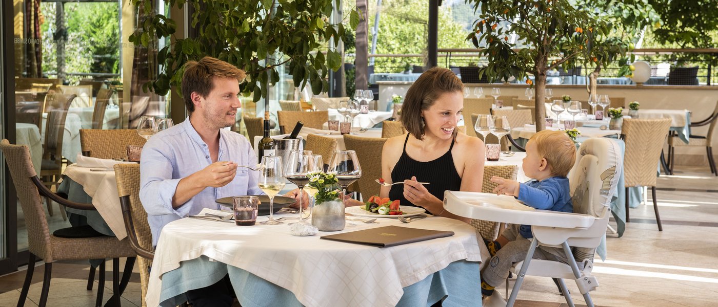 Wellness hotel with gourmet cuisine: Gartenhotel Moser Family dining together at a restaurant terrace with greenery around