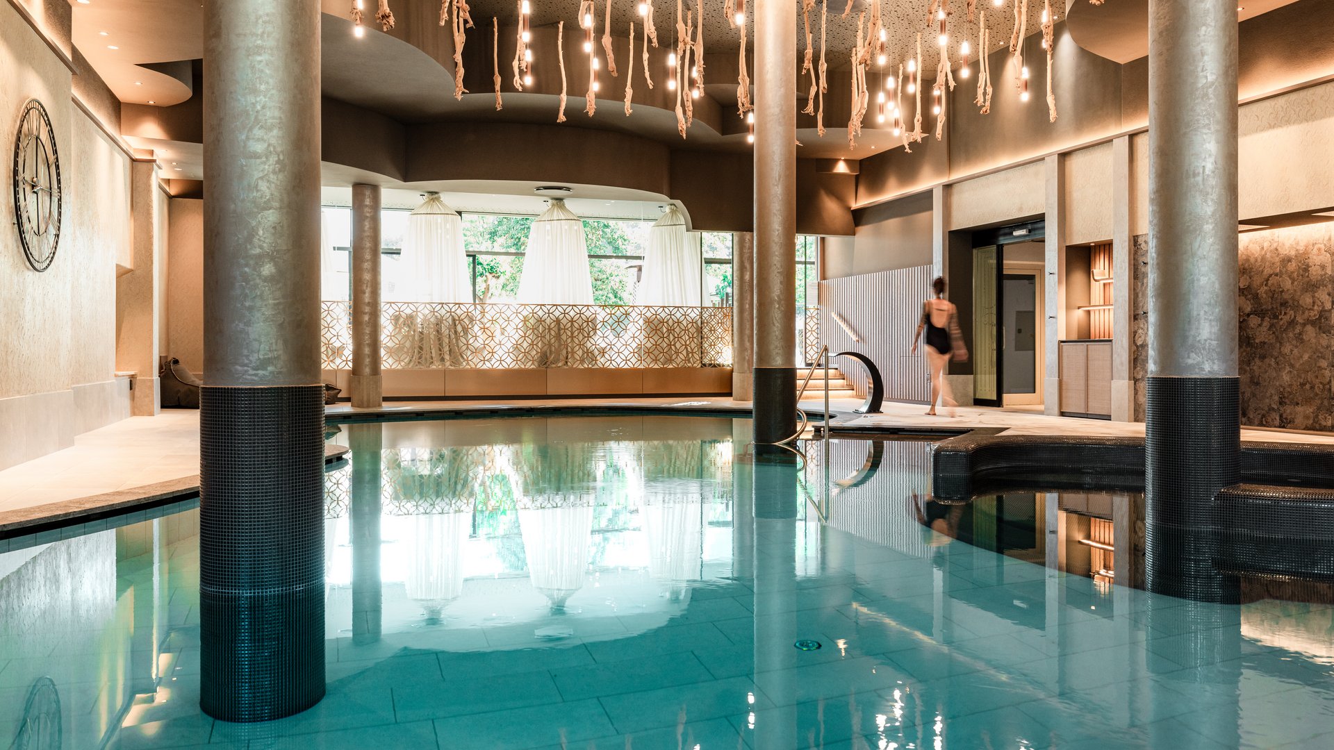 Urlaub in Südtirol im Hotel mit Pool am See Innenpool in modernem Spa mit Säulen und hängenden Lichtern