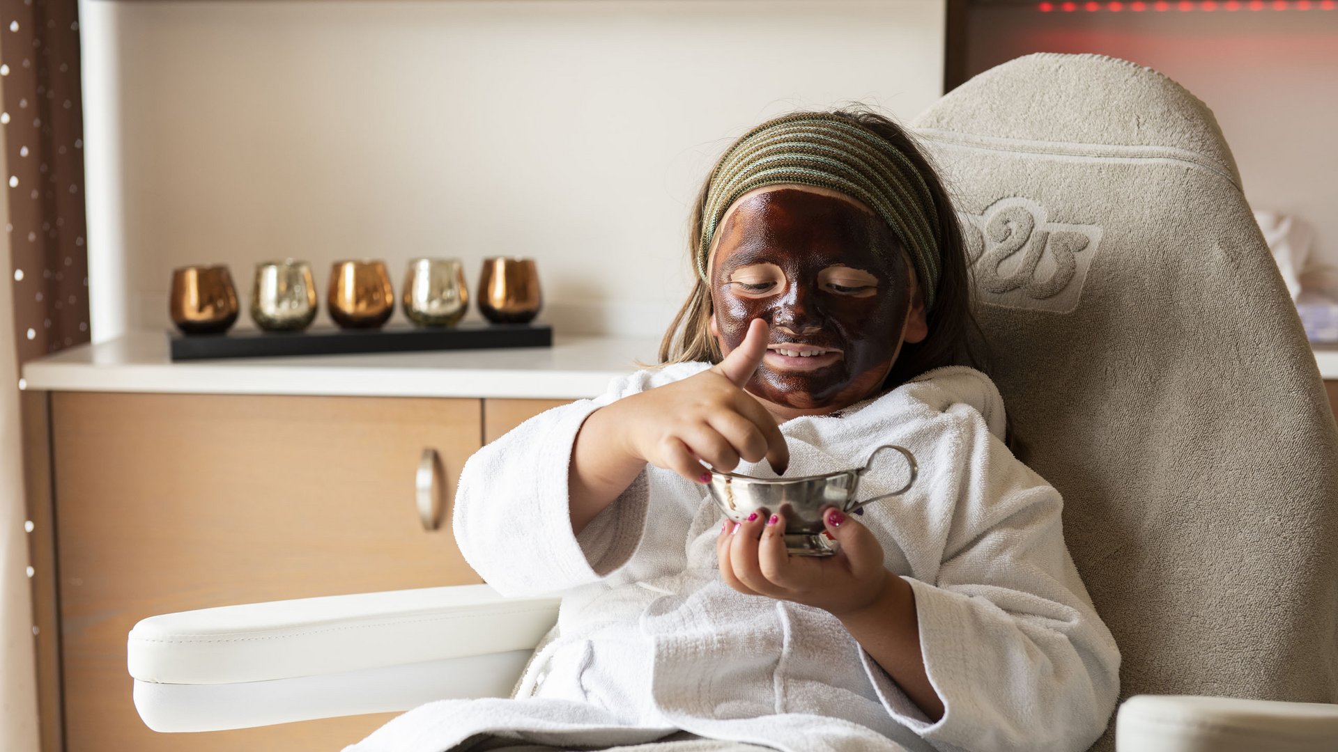 Family hotels in South Tyrol with 4-star-superior service Child with face mask relaxing in spa chair