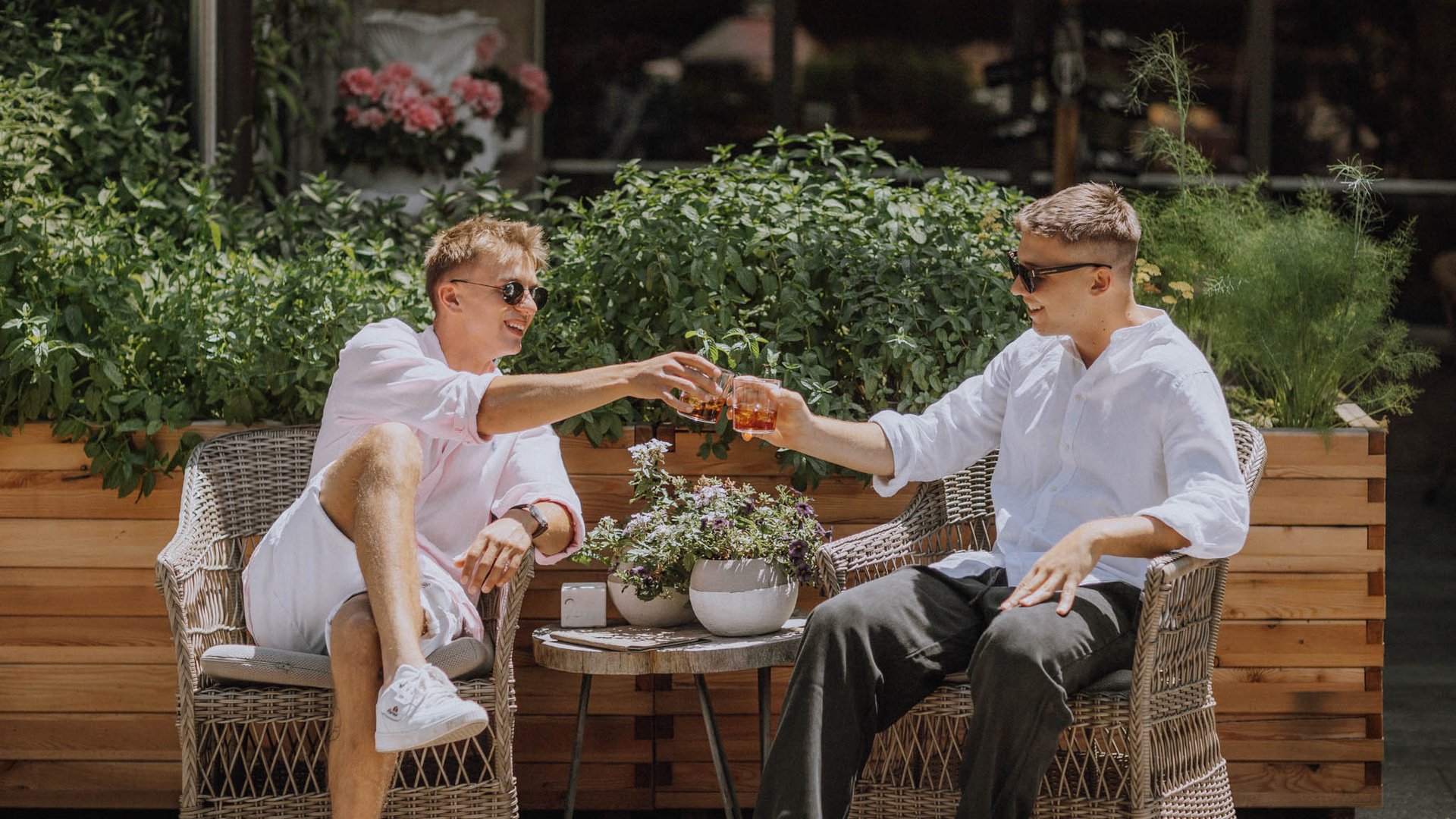 Two men toasting in the garden on a sunny day