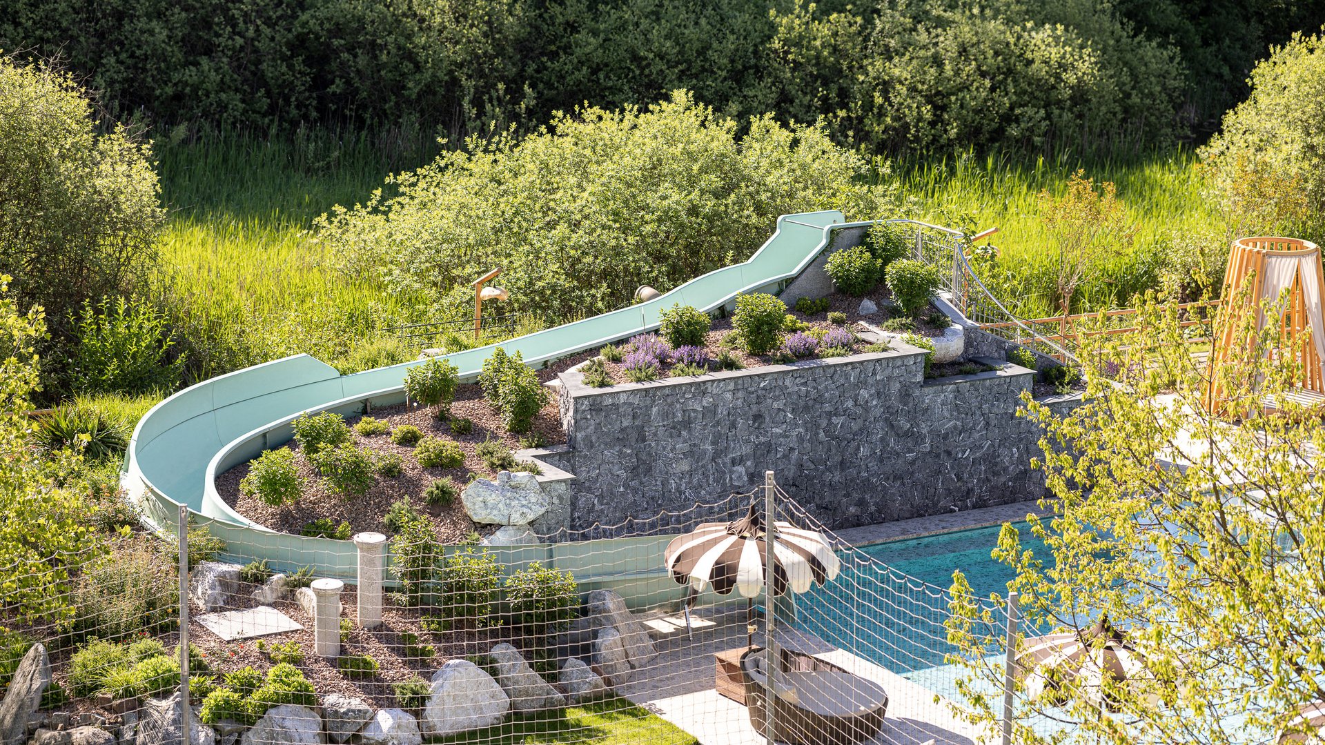 Hotel bei Eppan an der Weinstraße: Gartenhotel Moser Wasserrutsche neben Pool und grüner Gartenanlage im Freien