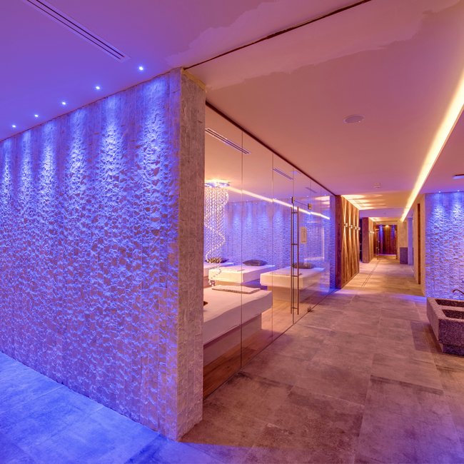 Day spa in South Tyrol: Gartenhotel Moser Modern hallway with blue lighting and stone walls in a spa or wellness center