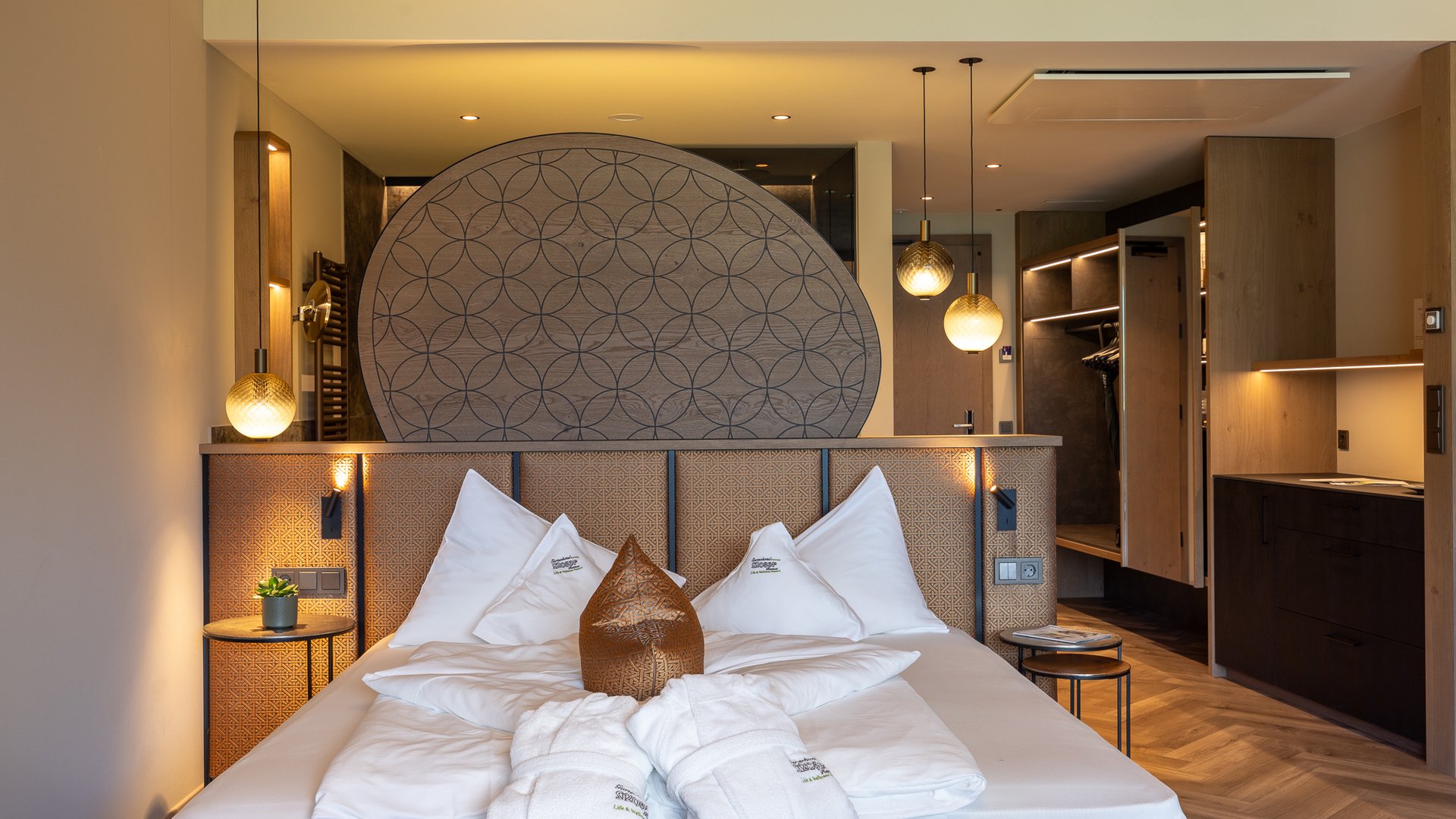 Novità a partire dal 2024 al Gartenhotel Moser Camera d'hotel moderna con testiera decorativa, letto e accappatoi