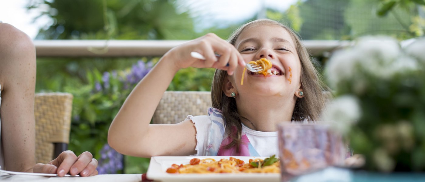 Hotel near Eppan an der Weinstraße: Gartenhotel Moser Girl laughing while eating spaghetti outdoors