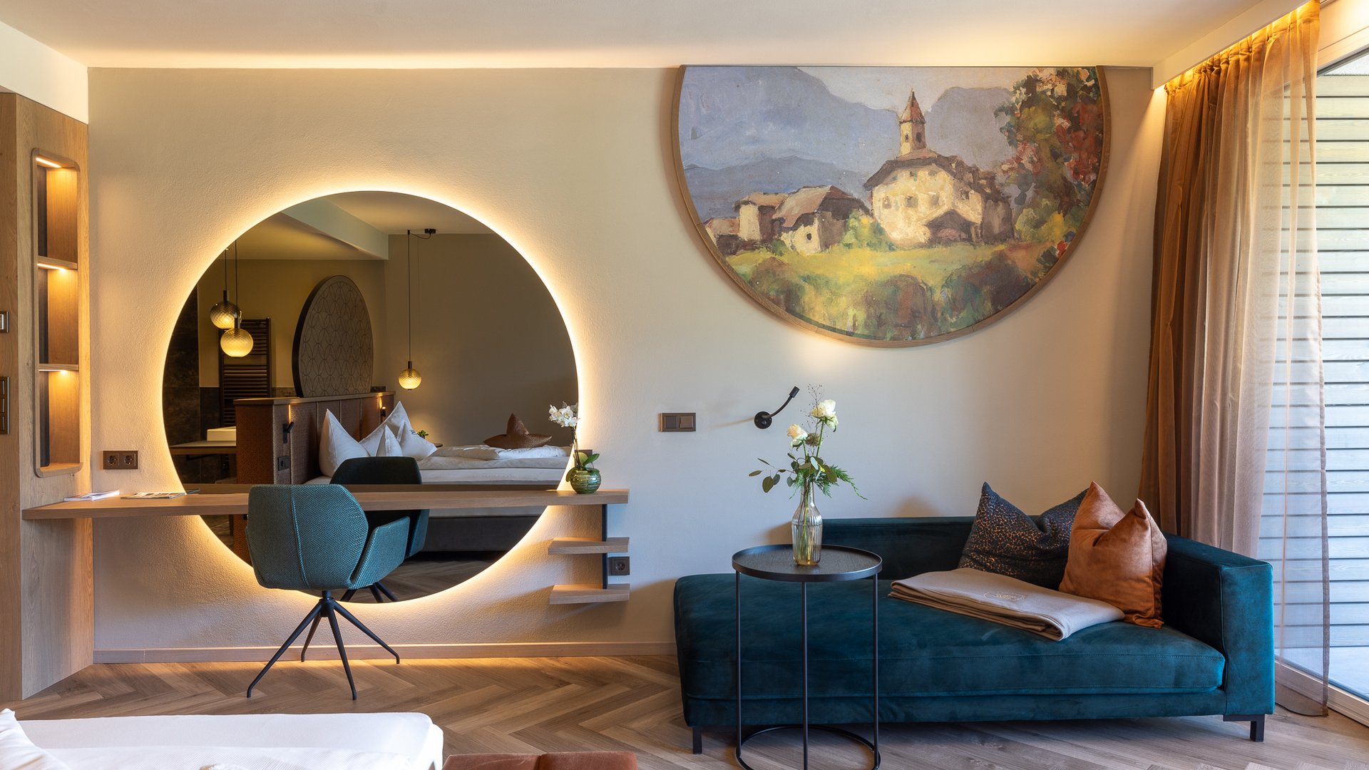 Hotels near Lago di Caldaro with 4-star superior service Modern living room with blue sofa, round mirror, and wall painting
