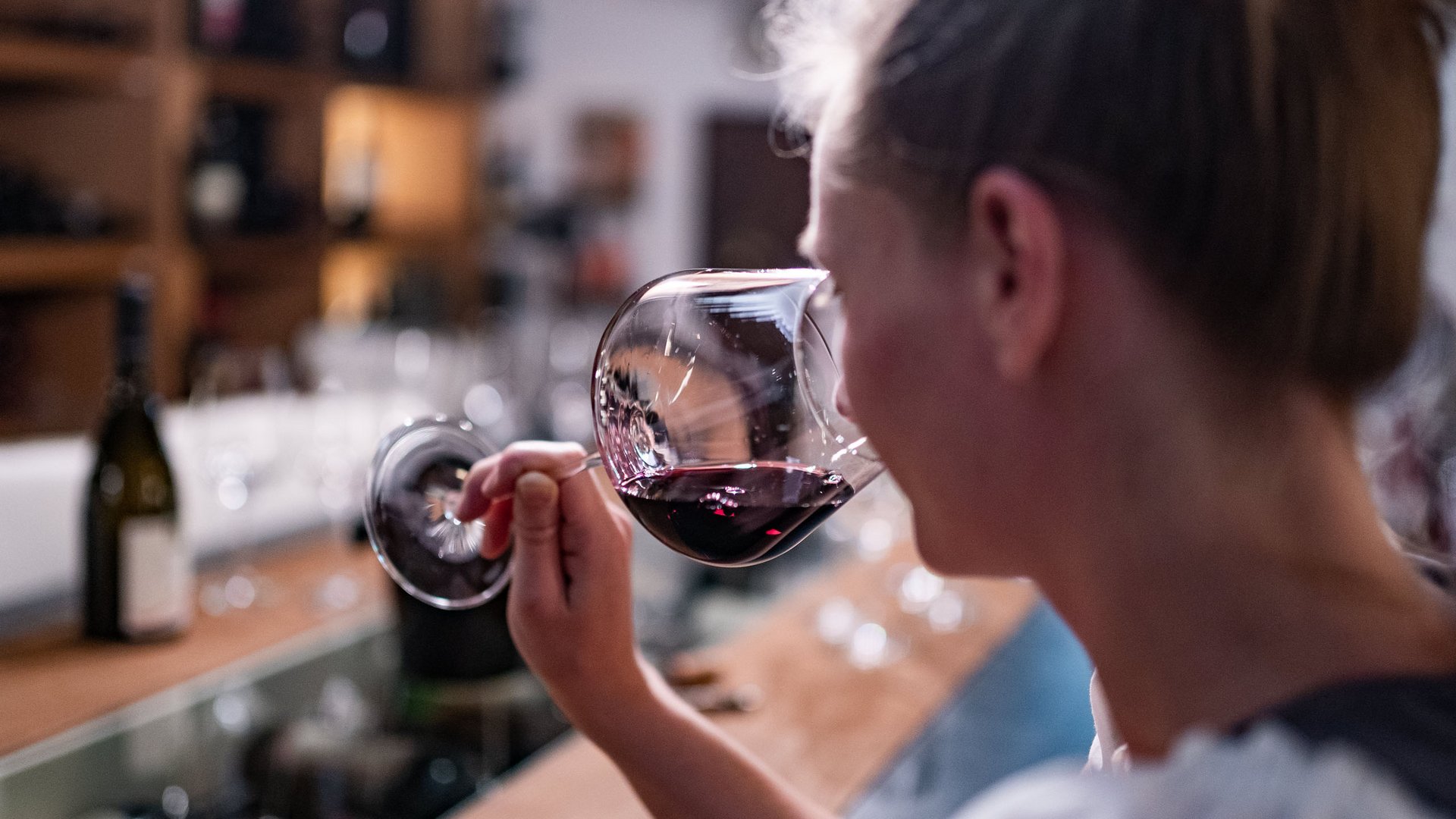 Un hotel senza glutine in Alto Adige: il Gartenhotel Moser Donna che annusa un calice di vino rosso in una degustazione