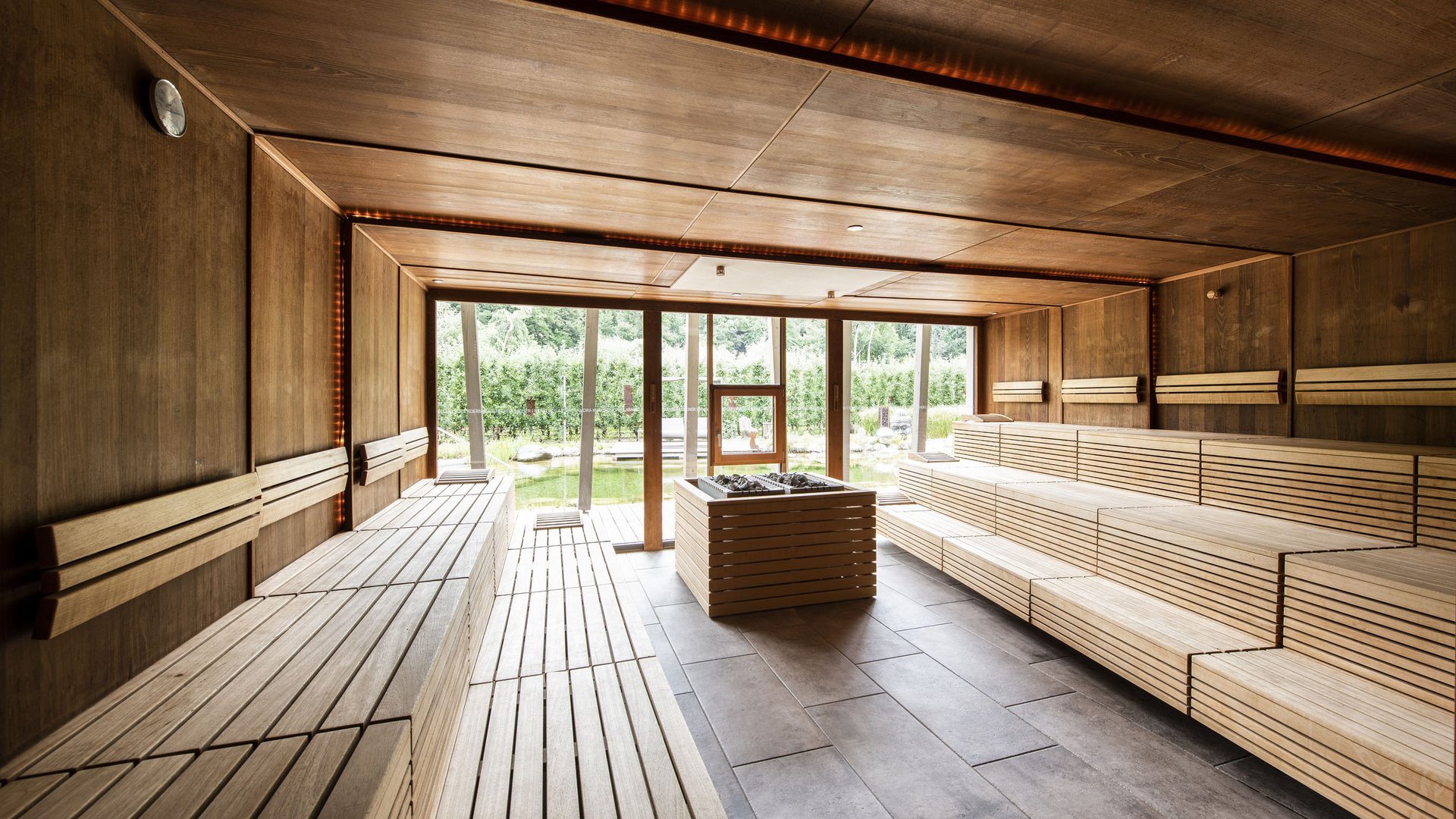 Hotels nahe dem Kalterer See 4-Sterne-Superior Innenansicht einer modernen Holzbiosauna mit Glasfenster zur Natur