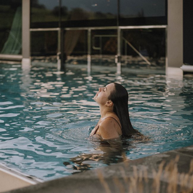 Day spa in South Tyrol: Gartenhotel Moser Woman relaxing in indoor pool with eyes closed