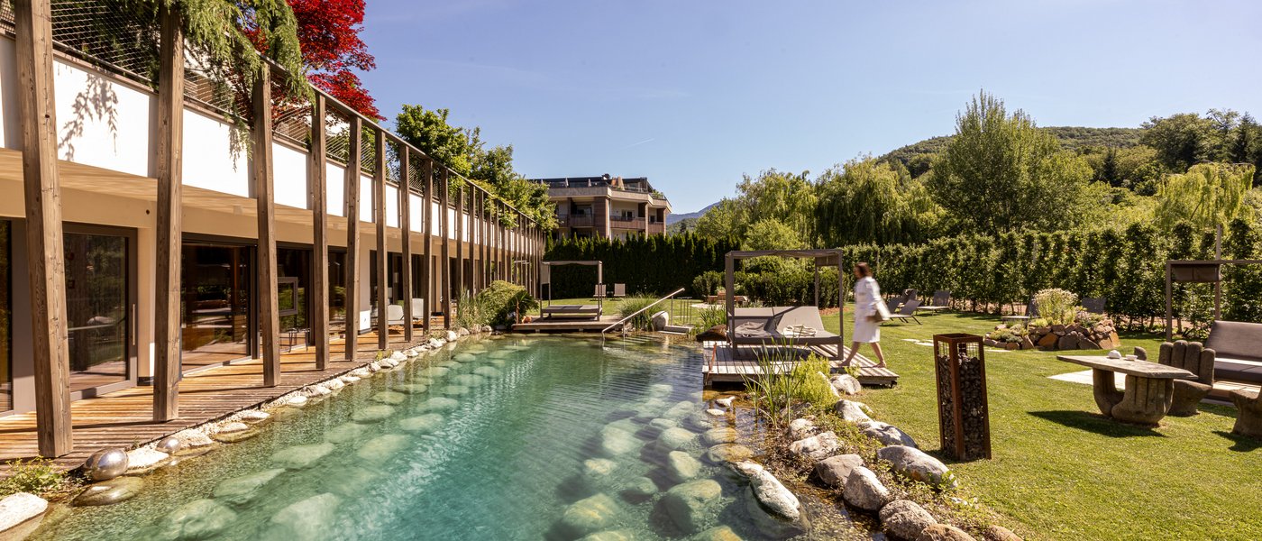 Hotel in Alto Adige con piscina Piscina esterna con pietre e lettini accanto a edificio moderno e giardino