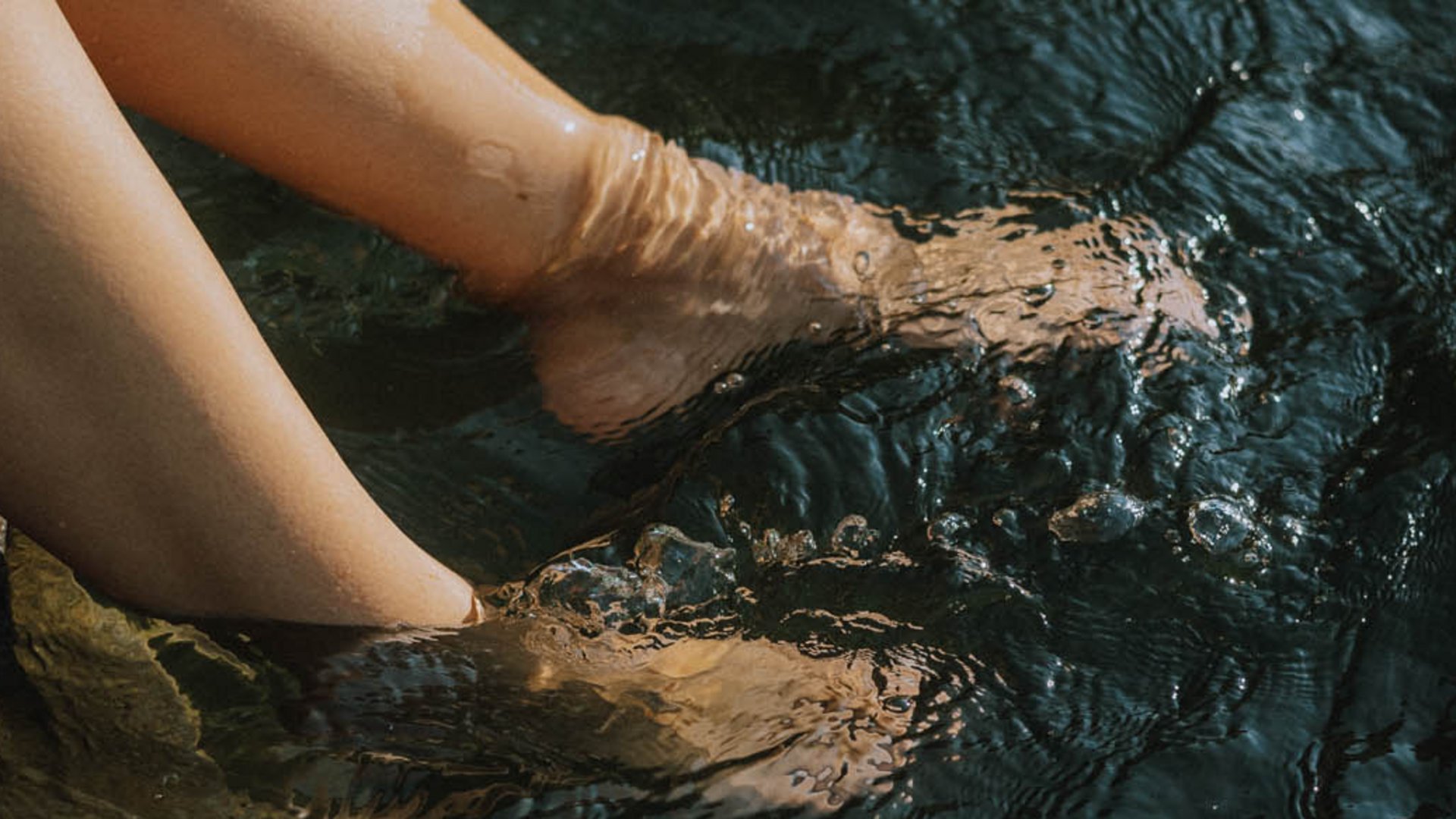 Hotel in Alto Adige con piscina Gambe immerse in acqua calma da una scaletta di metallo