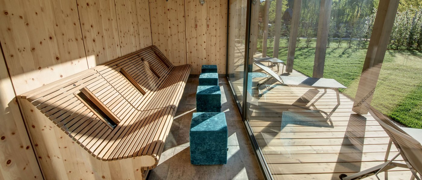 Wellness hotel with whirlpool and sauna world Wood sauna with glass wall overlooking outdoor terrace and garden