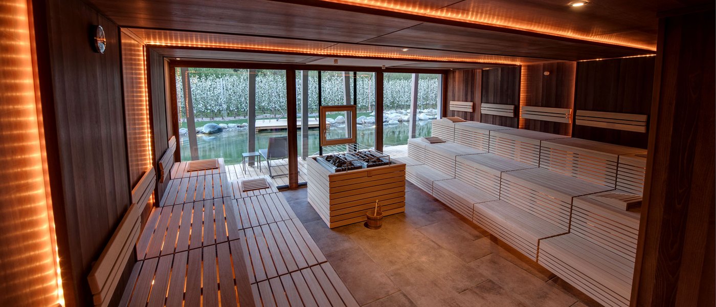 Wellness hotel with whirlpool and sauna world Modern sauna room with wooden benches and large windows overlooking garden