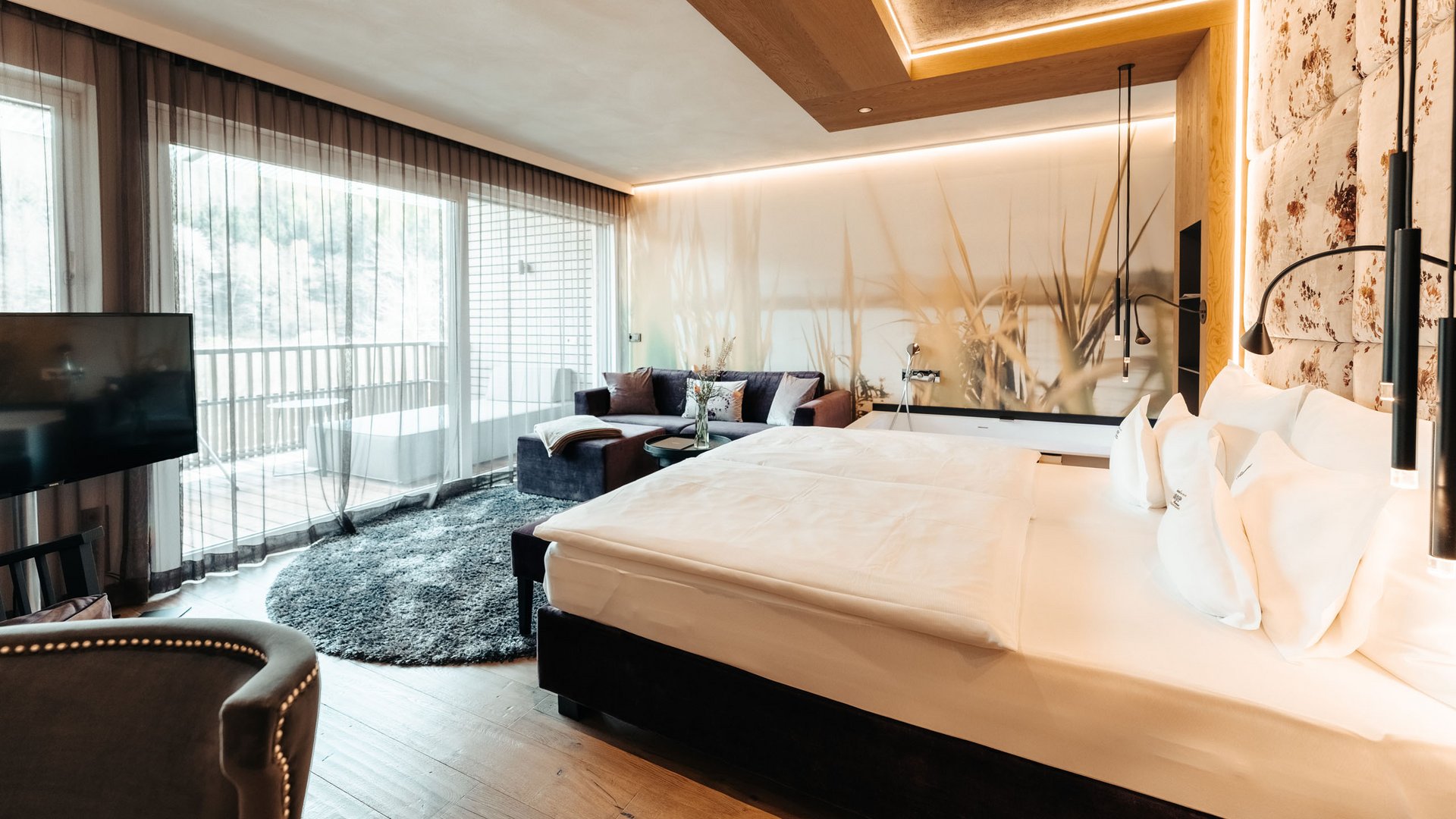 Hotel an der Weinstraße in Südtirol Elegantes Hotelzimmer mit Doppelbett, Sofa und Balkon mit Blick ins Freie