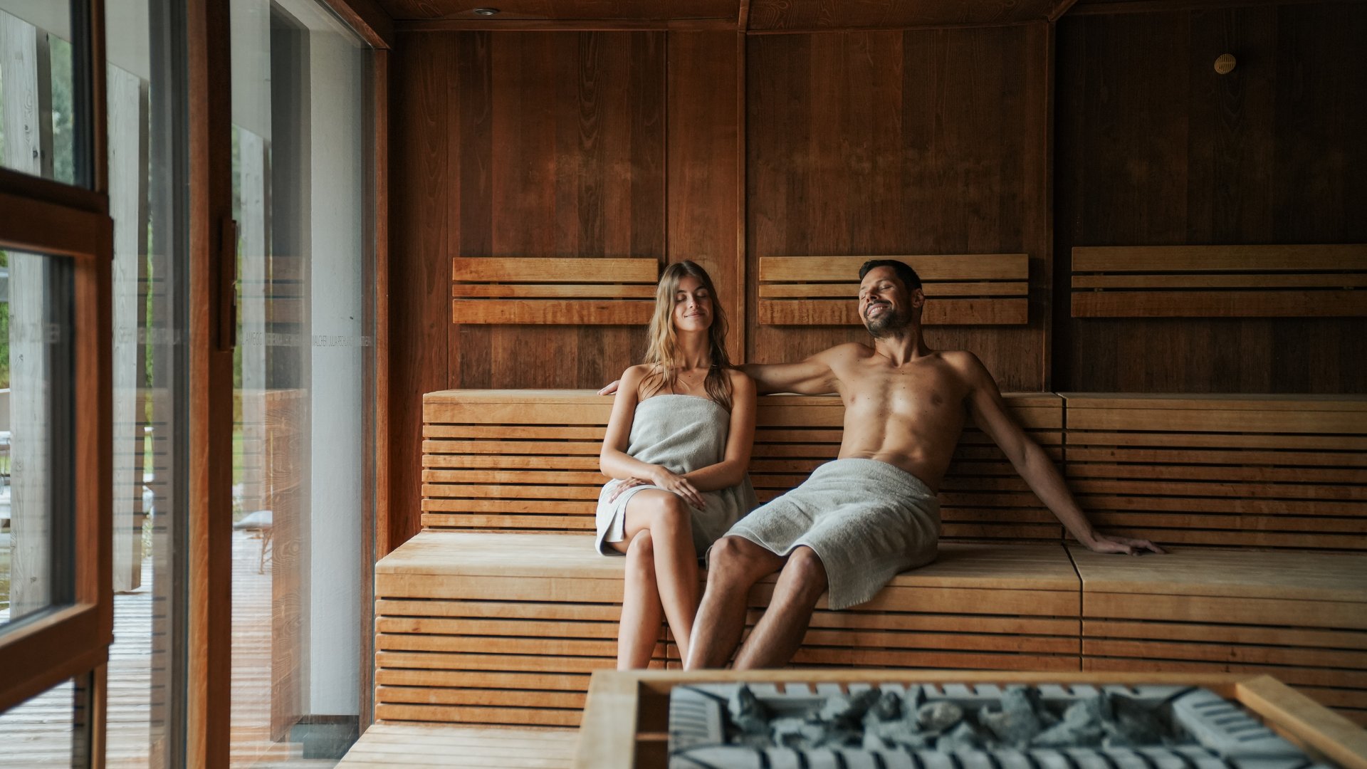 Day spa in South Tyrol: Gartenhotel Moser Couple relaxing together in a wooden sauna room