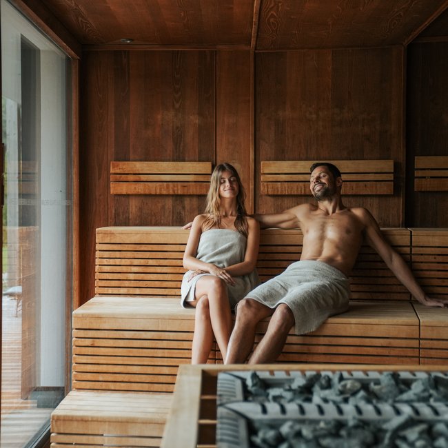 Day spa in South Tyrol: Gartenhotel Moser Couple relaxing together in a wooden sauna room