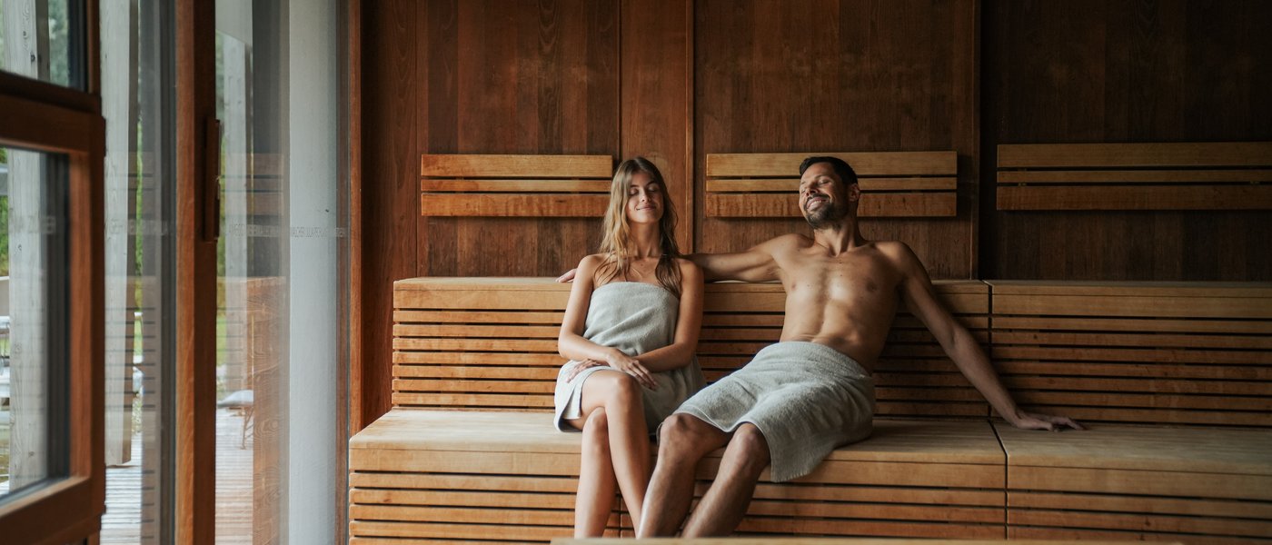 Wellnesshotel mit Whirlpool und Saunawelt Ein Paar entspannt in einem Saunaraum aus Holz