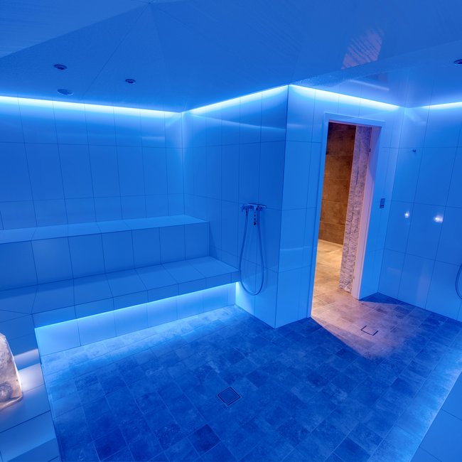Day spa in South Tyrol: Gartenhotel Moser Modern wellness steam room with blue lighting and white tiled walls