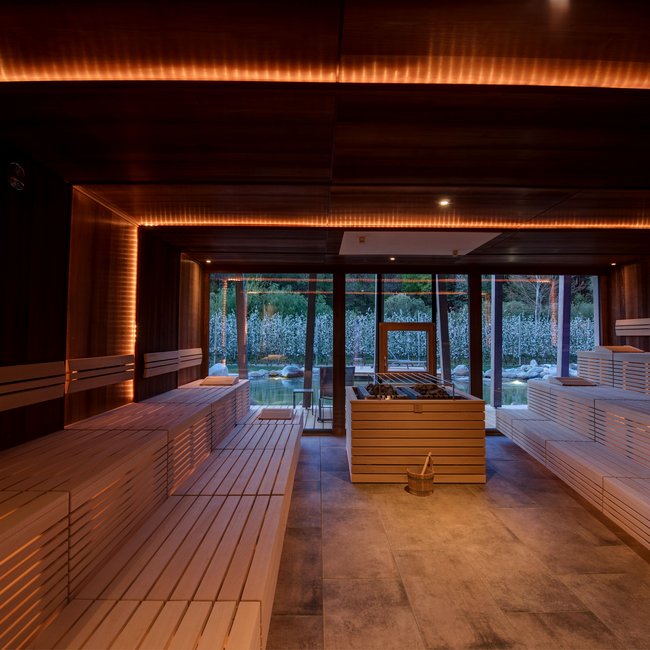 Day spa in South Tyrol: Gartenhotel Moser Modern sauna with wooden benches and panoramic garden view