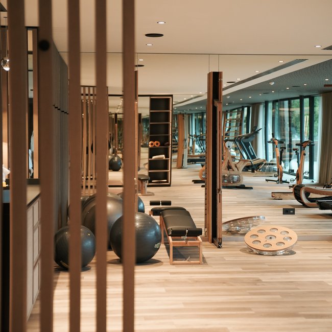 Sporthotels in Südtirol: Gartenhotel Moser Moderner Fitnessraum mit Holzgeräten und großen Spiegeln
