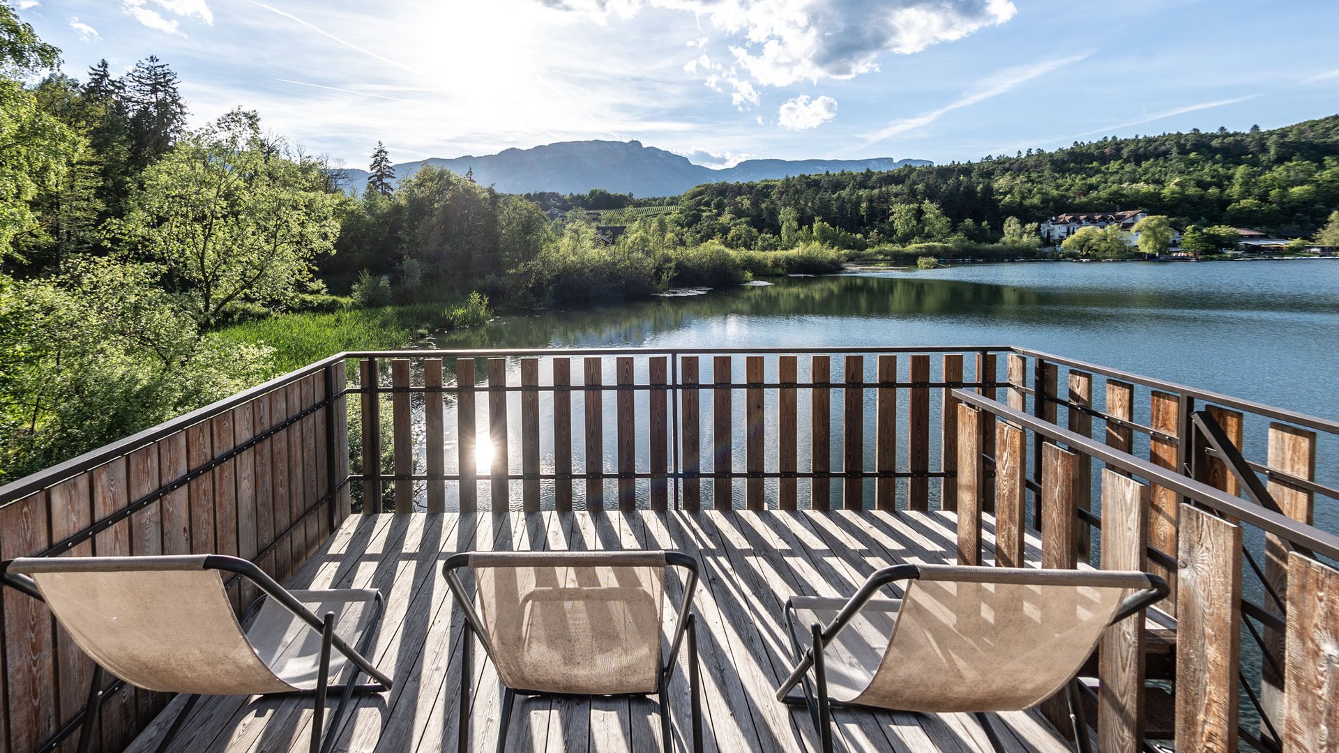 Lakeside wellness holiday: Gartenhotel Moser Three chairs on deck overlooking lake and mountains in sunlight