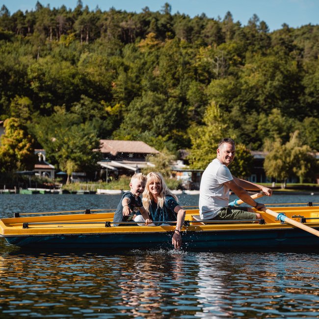 Lakeside wellness holiday: Gartenhotel Moser Family in a yellow rowboat on a lake on a sunny day