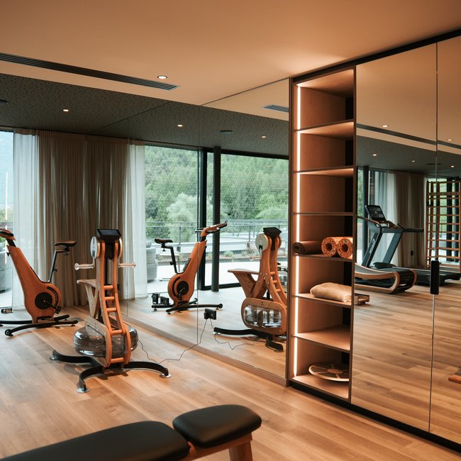 Sporthotels in Südtirol: Gartenhotel Moser Moderner Fitnessraum mit Holzgeräten und großen Spiegeln