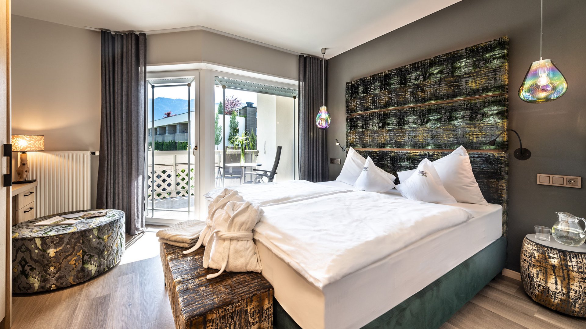 Hotel an der Weinstraße in Südtirol Modernes Hotelzimmer mit Terrasse, zwei Einzelbetten und dekorativen Lampen