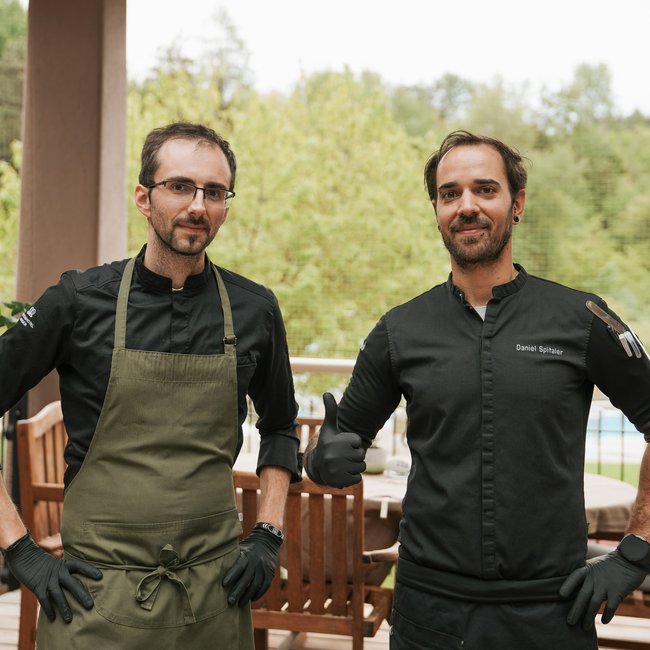 Im Wellnesshotel glutenfrei genießen Zwei Köche auf Terrasse, einer mit grünem Latz und einer mit schwarzer Jacke