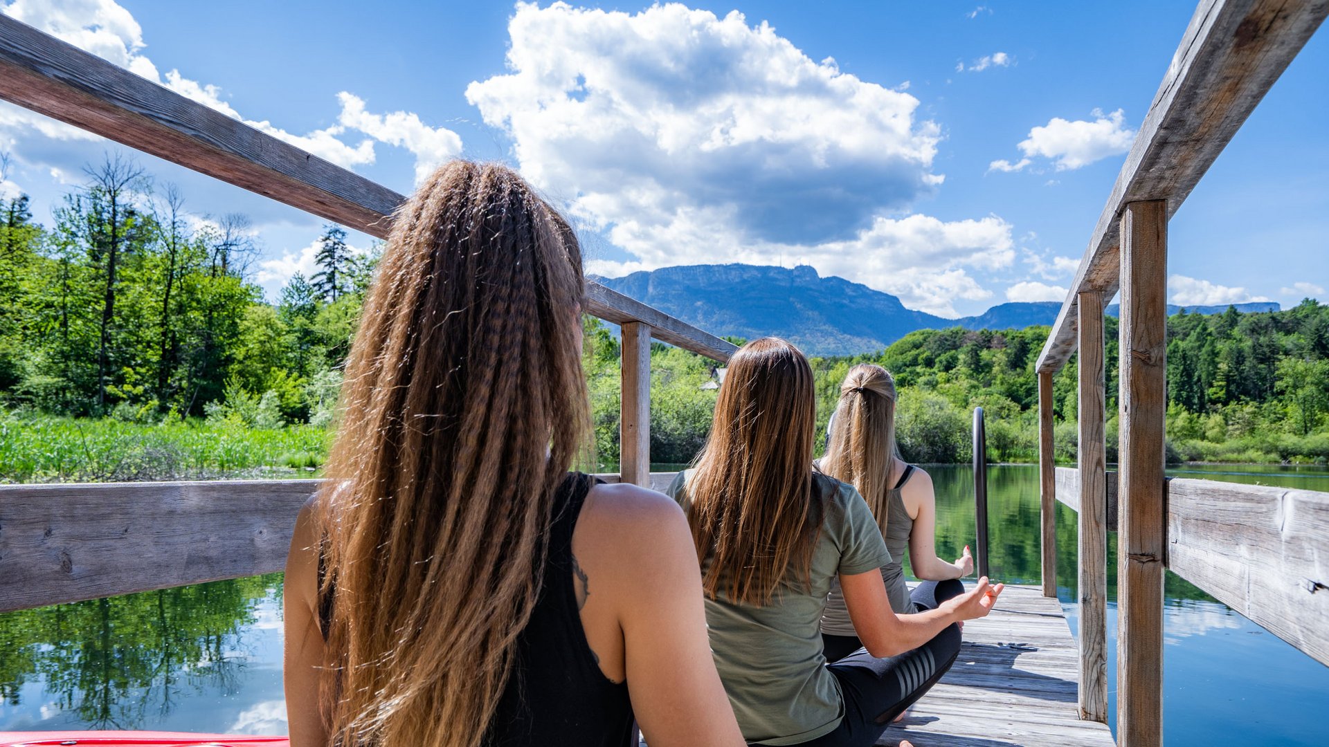 Lakeside wellness holiday: Gartenhotel Moser Three women meditating on dock with lake and mountain view