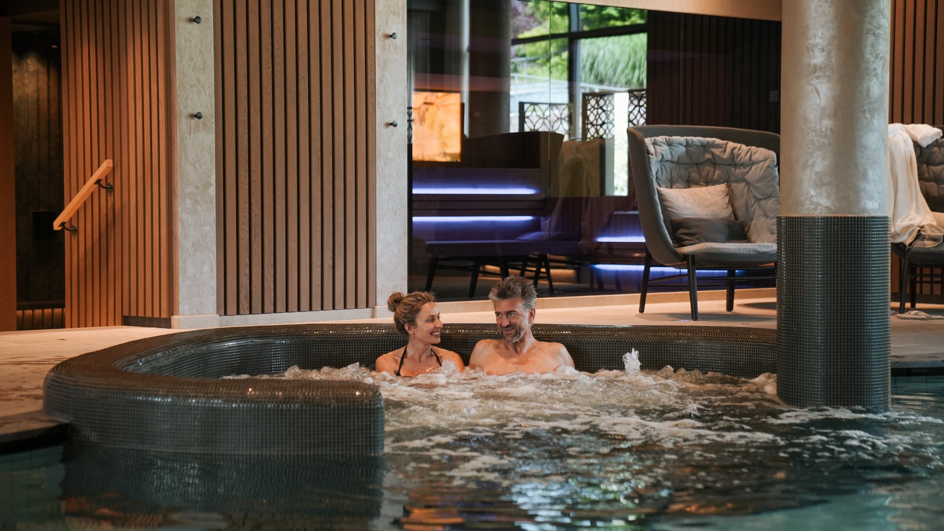 Hotel wellness in Alto Adige per soli adulti Coppia rilassata nella vasca idromassaggio di una spa moderna