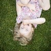 Hotels near Lago di Caldaro with 4-star superior service Smiling little girl lying on grass holding her nose