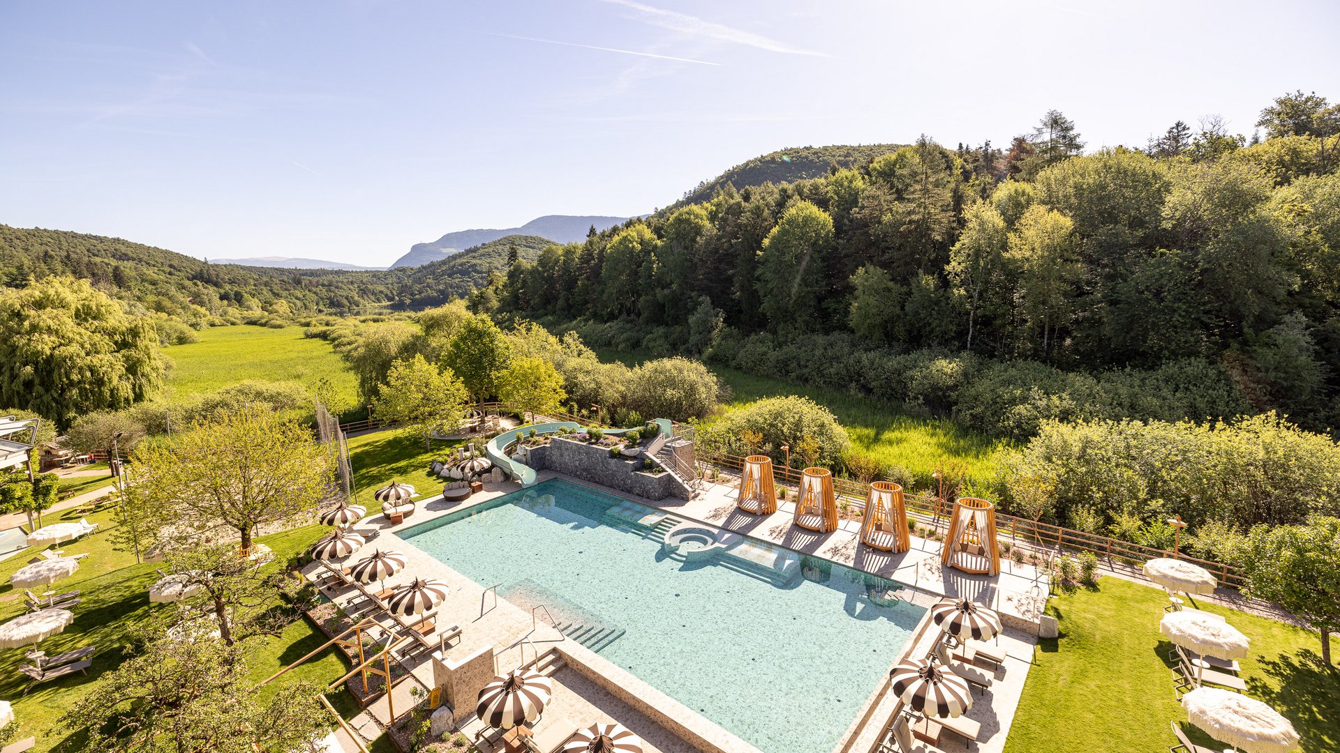 Hotel al Lago di Monticolo: il Gartenhotel Moser Piscina all'aperto con ombrelloni e lettini in paesaggio verde