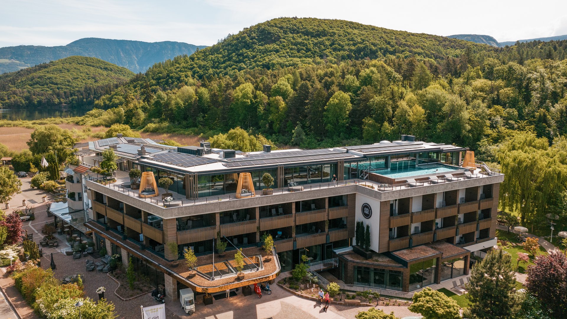 Hotels in Eppan, Südtirol: Anfahrt Moderne Unterkunft mitten in grüner, hügeliger Landschaft mit Wald im Hintergrund