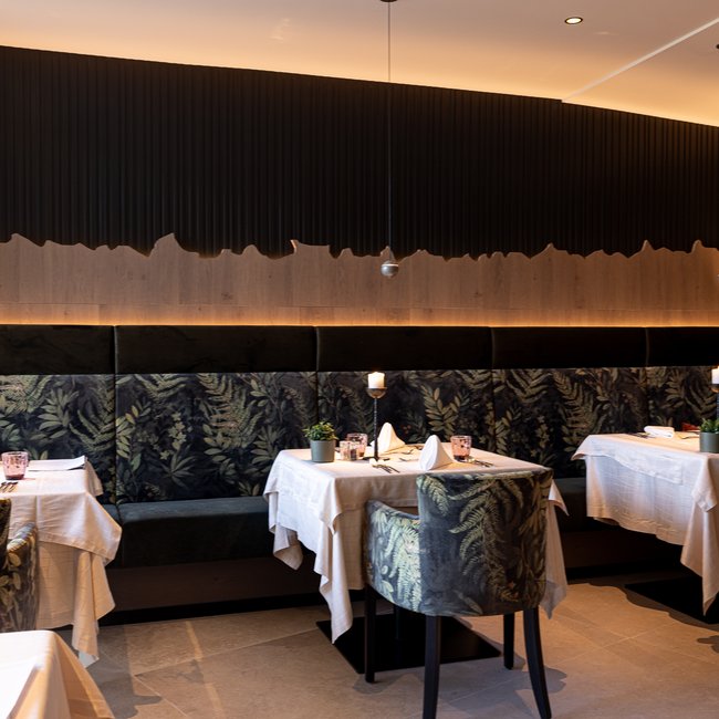 Neu ab 2024 im Gartenhotel Moser Gemütlicher Restaurantbereich mit eingedeckten Tischen und Musterpolsterung