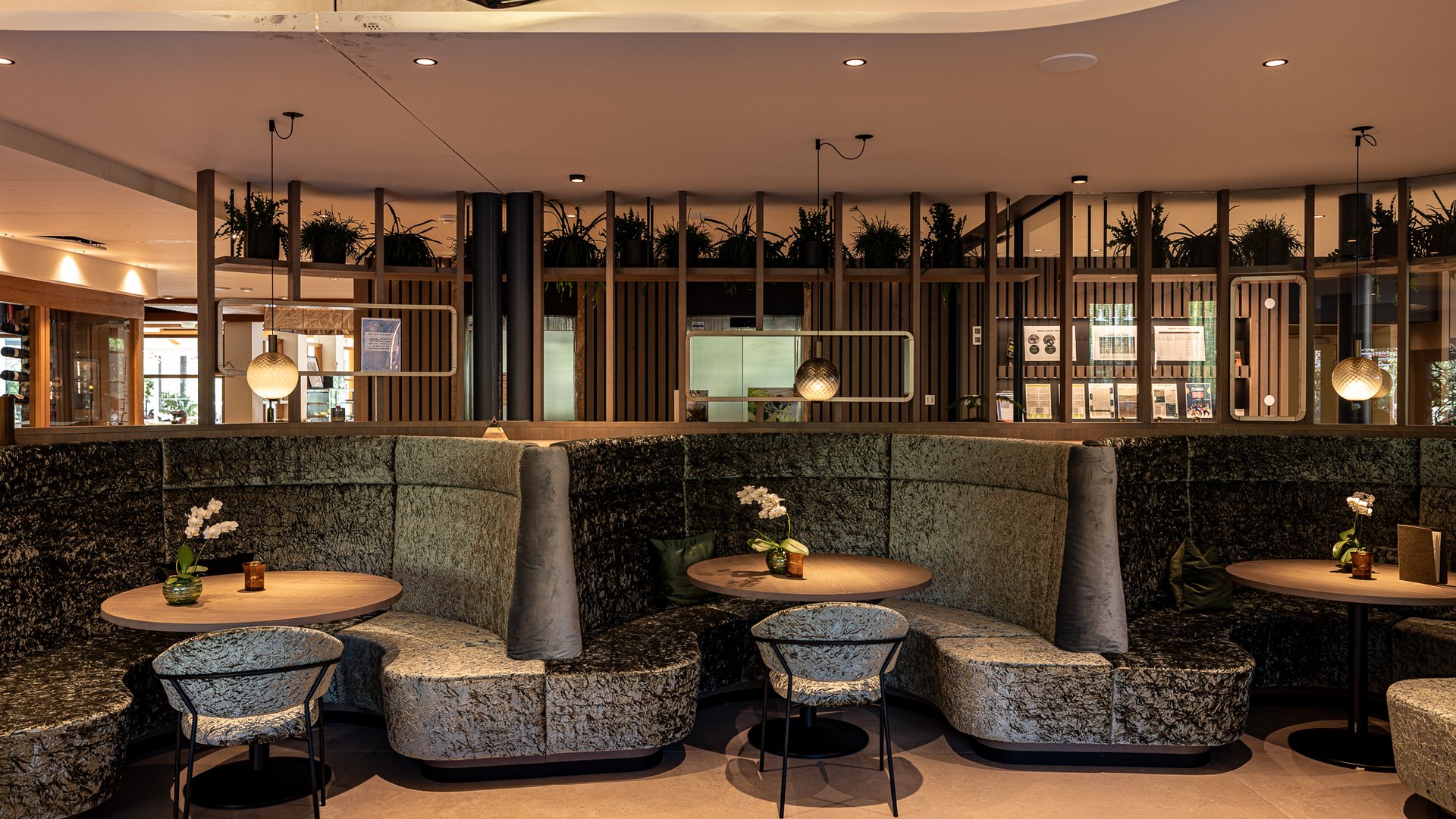Novità a partire dal 2024 al Gartenhotel Moser Accogliente area salotto rotonda con tavoli e piante in un caffè moderno