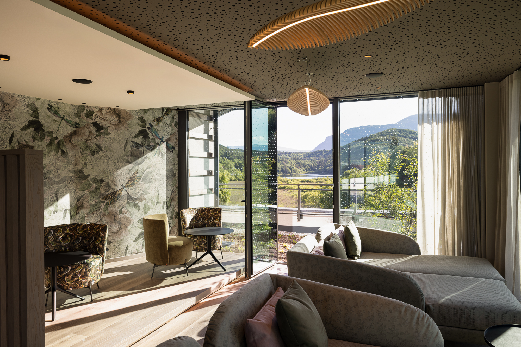 Novità a partire dal 2024 al Gartenhotel Moser Zona soggiorno accogliente in hotel con vista su montagne verdi e lago